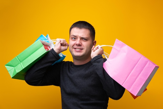 Foto van man met veelkleurige boodschappentassen