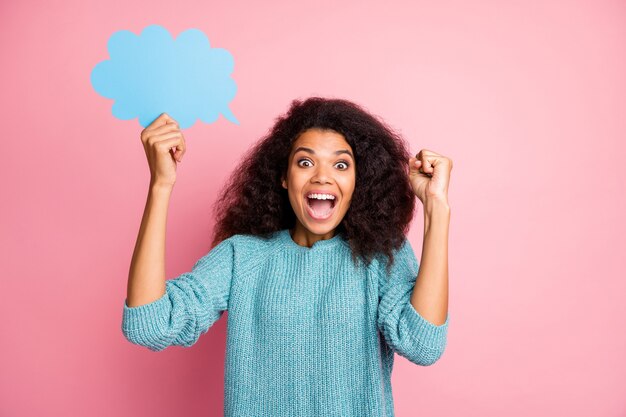 Foto van modieuze bruinharige krullende golvende trendy vrolijke casual vrouw met bubbel met copyspace emoties uitdrukken op gezicht geïsoleerd in blauwe trui pastel roze kleur muur