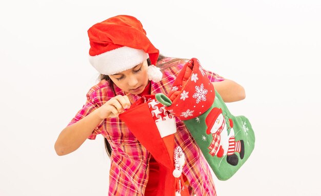 Foto van mooi charmant meisje houdt nieuwjaarskous kerstcadeau geïsoleerd witte achtergrond