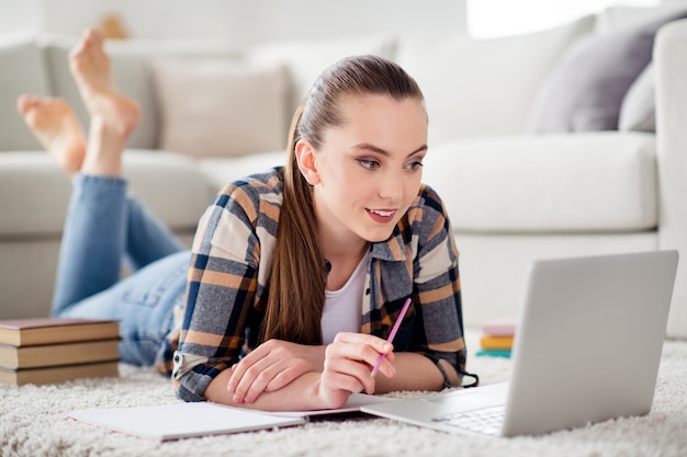 Foto foto van mooie dame student browsen notitieboekje liegen vloer kijken les luister leraar notities schrijven