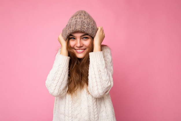 Foto van mooie gelukkig lachende grappige jonge brunette vrouw geïsoleerd over roze achtergrond muur