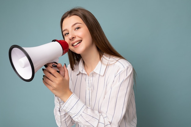 Foto van mooie innemende positieve gelukkig lachende donkerblonde jonge vrouw met oprechte emoties