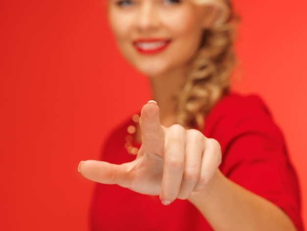 foto van mooie vrouw in rode jurk die op virtuele knop drukt