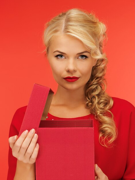 foto van mooie vrouw in rode jurk met geopende geschenkdoos