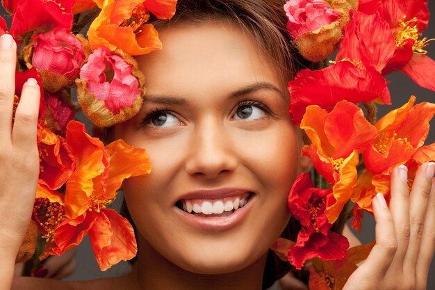 Foto foto van mooie vrouw met rode bloemen