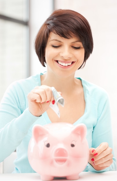 foto van mooie vrouw met spaarvarken en geld