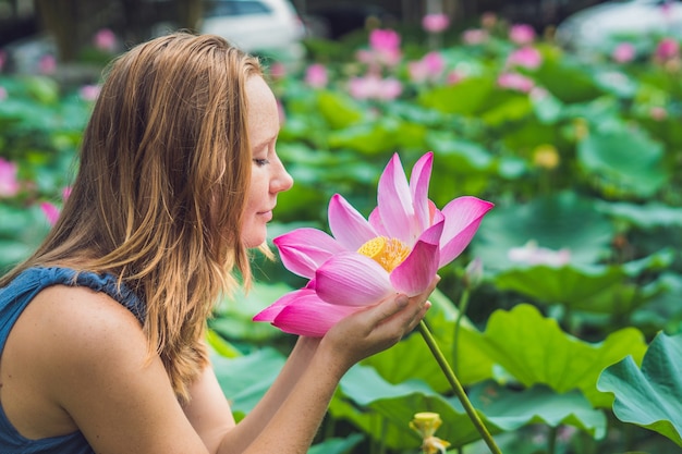 Foto van mooie vrouw Roodharige met lotusbloem in hand