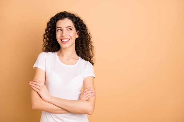 Foto van mooie zakelijke dame gekruiste armen op zoek sluw naar lege ruimte nadenken over lastig plan witte vrijetijdskleding dragen geïsoleerde beige pastelkleur achtergrond