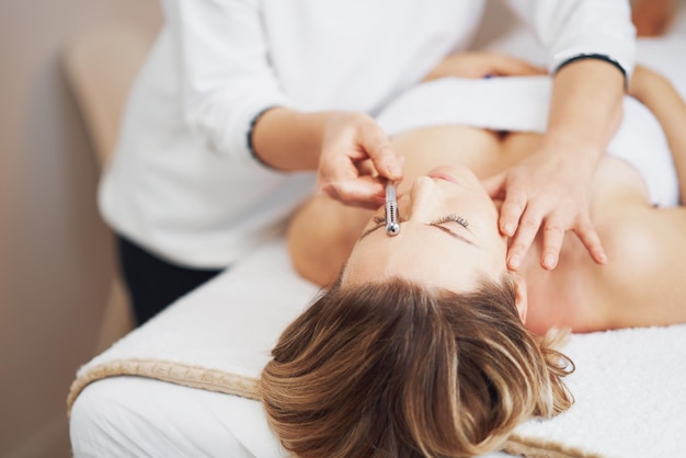 Foto van moxibustion-rollerbehandeling op vrouwengezicht