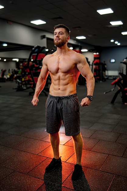 Foto van persoonlijke fitnesstrainer in sportschool poseren voor de camera. Gezond leven en fitness concept.