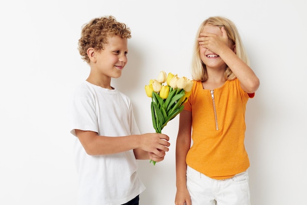 Foto van positieve jongen en meisje leuk verjaardagscadeau verrassing boeket bloemen levensstijl ongewijzigd