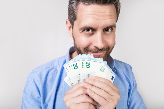 Foto van positieve man met geld verdienen man met geld verdienen geïsoleerd op studio