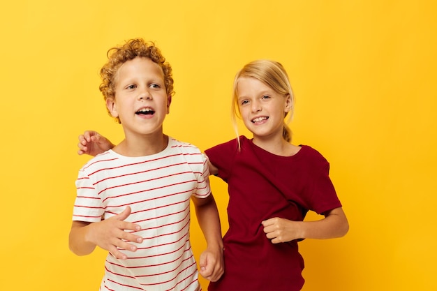 Foto van positieve vrijetijdskleding voor jongens en meisjes, leuk samen op een gekleurde achtergrond