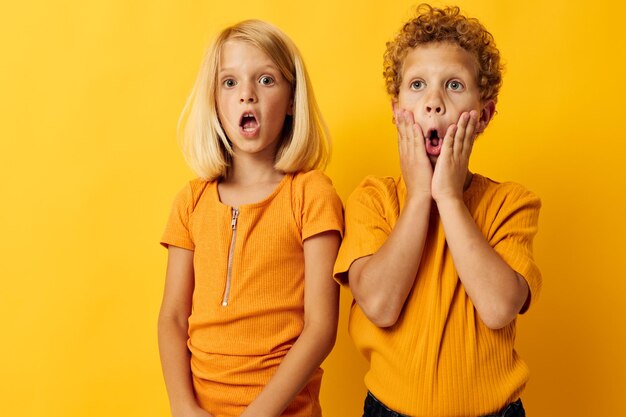 Foto van positieve vrijetijdskleding voor jongens en meisjes, leuk samen poseren op een gekleurde achtergrond