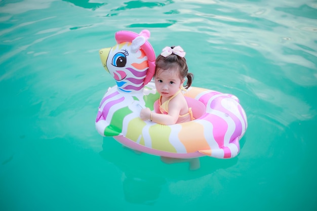 Foto van schattig klein meisje met moeder Kleurrijke eenhoorn opblaasbare ring zwemmen in een tropische oceaan op zomervakantie Hoogwaardige fotokopieerruimte voor tekst