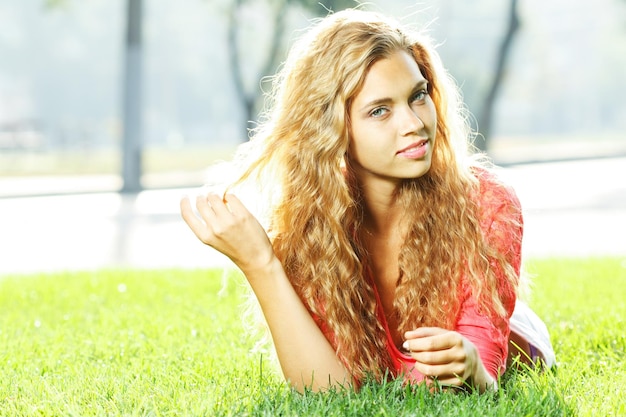 Foto van schattige blonde vrouw die op kamille veld ligt en omhoog kijkt in de lucht zonnige dag warm weer lente vakantie en vakantie mooie vrouw die geniet van prachtige natuur daisy veld