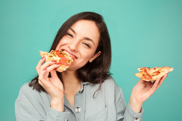 Foto van schattige dame eet pizza, geniet van junkfood