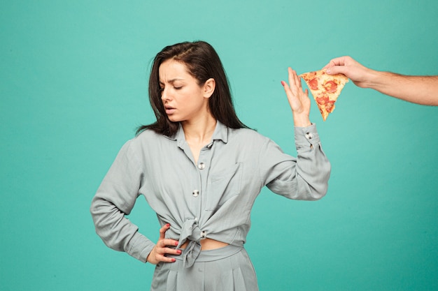 Foto van schattige dame is het afwijzen van pizza, gezonde levensstijl, geen junkfood