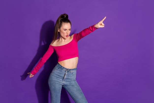 Foto van schattige flirterige jonge dame geeft aan dat vingers lippen lucht kus sturen, jeans roze top geïsoleerde violette kleur achtergrond dragen