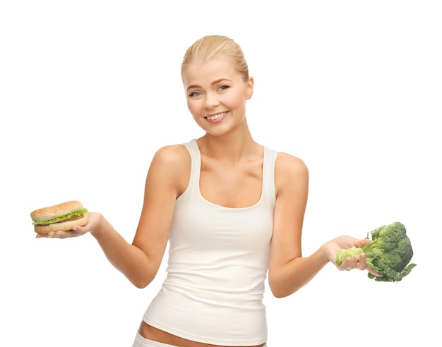 foto van sportieve vrouw met broccoli en hamburger