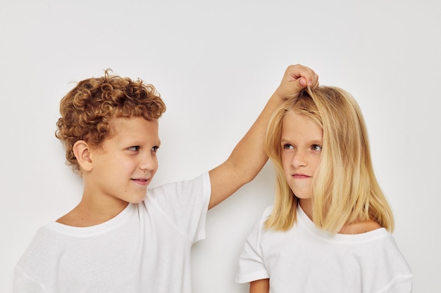 Foto van twee kinderen in witte T-shirts staan ongewijzigd naast de kindertijd