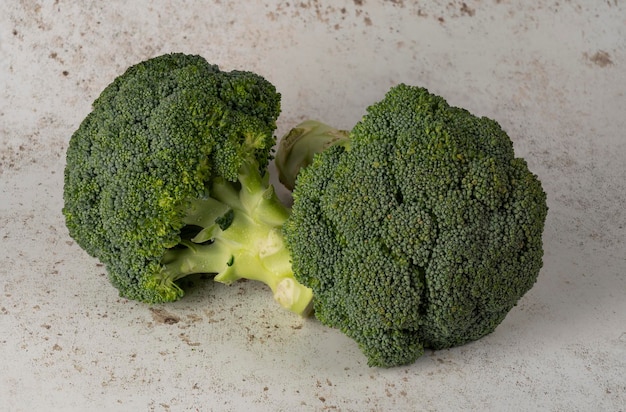 Foto van twee prachtige stengels van broccoli geïsoleerd op een achtergrond die een rustieke tafel nabootst