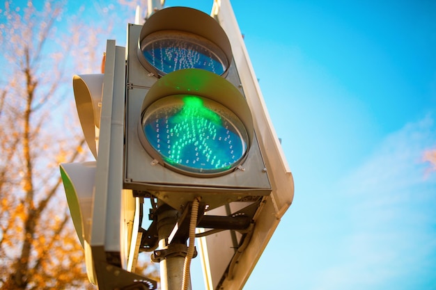 Foto van verkeerslicht met groene man close-up op achtergrond van blauwe hemel