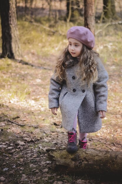 Foto foto van vintage stijl geklede meisje spelen in het bos