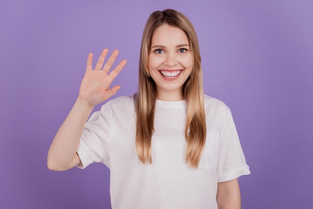 Foto van vriendelijke aardige dame, vrolijke stemmingsgolf met de hand, casual t-shirt op violette achtergrond