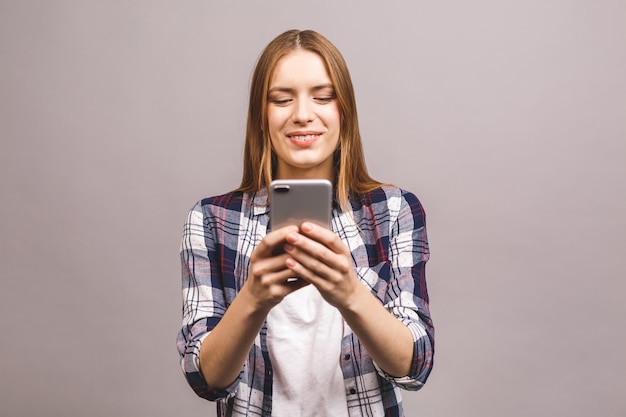 Foto van vrolijke leuke mooie jonge vrouw chatten via de mobiele telefoon.