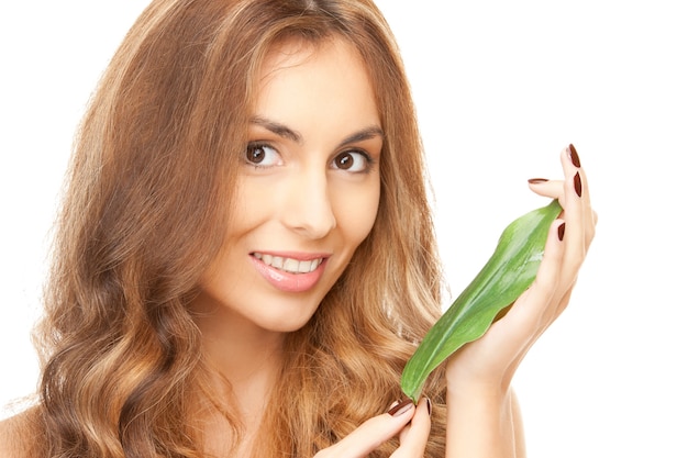 Foto van vrouw met groen blad over wit