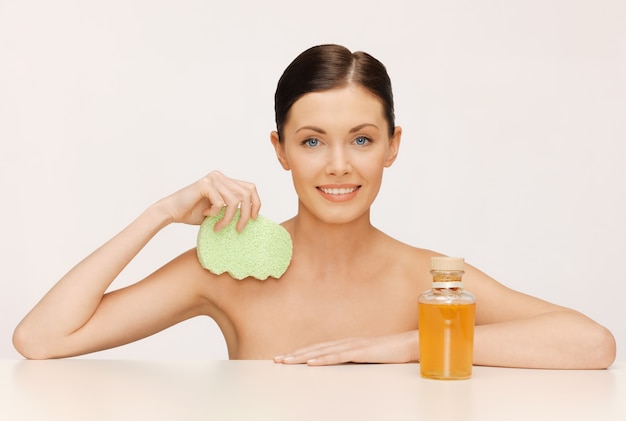 foto van vrouw met spons en cosmetische flessen