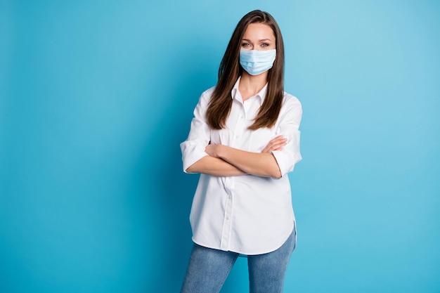 Foto van zakelijke dame armen handen gekruist goed humeur draag gasmasker wit overhemd jeans geïsoleerd blauwe kleur achtergrond