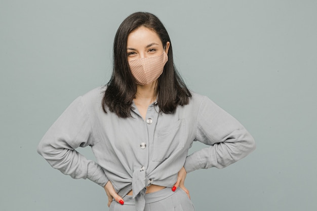 Foto vrouw in gezichtsmasker stands en glimlach