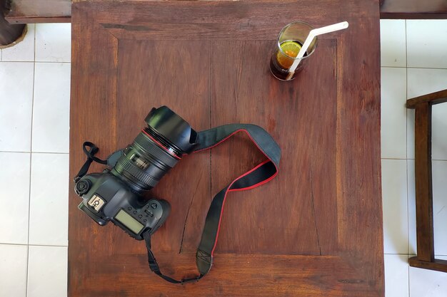 Fotocamera en glas cola met citroen op een houten tafel Plat buiten leggen