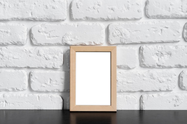 Fotoframe met kopieerruimte tegen een witte bakstenen muur