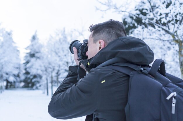 Fotograaf die foto's maakt in een besneeuwd landschap op een koude winterdag