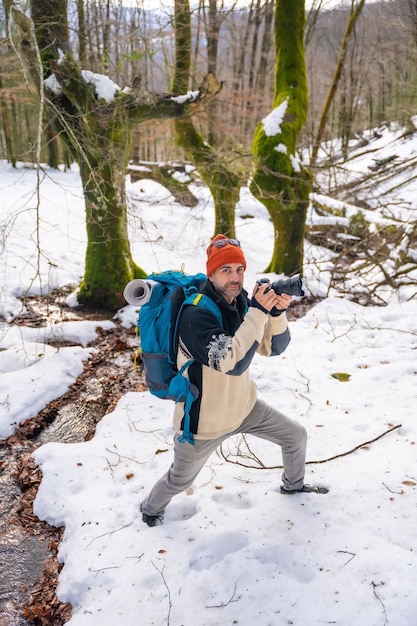 Fotograaf geniet van het maken van foto's in de winter in een besneeuwd bos winterhobby's