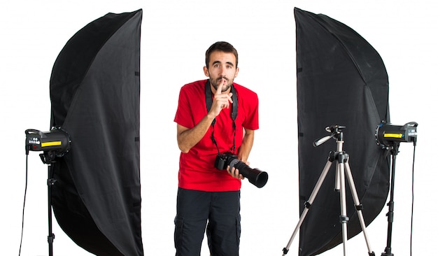 Fotograaf in zijn studio stilte gebaar maken