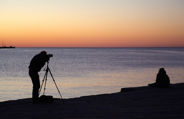 Fotograaf maak een foto bij zonsondergang