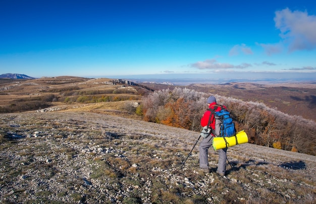 Fotograaf maakt foto's op de top van de berg in de herfst. Reiziger met rugzak genietend van uitzicht vanaf de bergtop