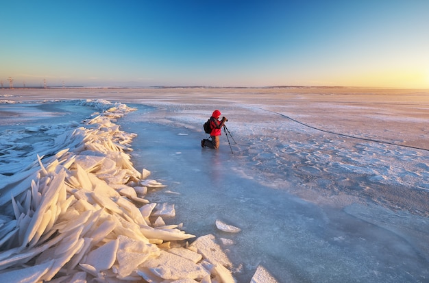 Fotograaf maakt in de winter foto's op de oever van de rivier