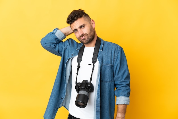 Fotograaf man geïsoleerd op gele achtergrond met twijfels