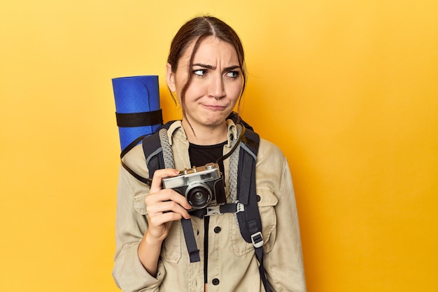 Fotograaf met uitrusting klaar om te verkennen verward voelt zich twijfelachtig en onzeker