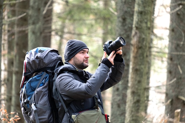 Fotograaf met wandelrugzak die foto's van de natuur maakt met een digitale fotocamera.