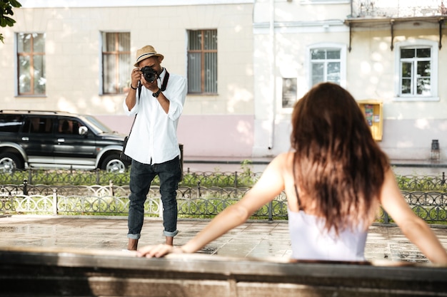 Fotograaf neemt foto van jonge mooie brunette vrouw in park