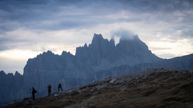 Fotografen voor scherpe torenhoge bergen die zich voorbereiden op een fotoshoot bij zonsopgang in Italië Europa