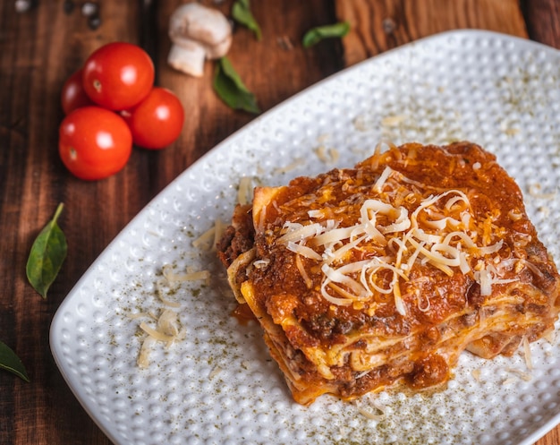 Fotografia de Lasagna en una mesa de madera con ingredientses frescos, 유리 우가르테 세스페데스