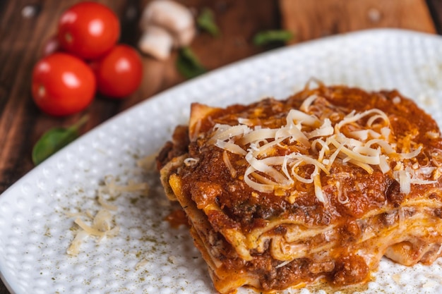 Fotografia de Lasagna en una mesa de madera con ingredientses frescos, 유리 우가르테 세스페데스