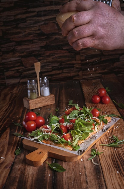 Fotografia de Pizza en een mesa de madera met fresco's van ingrediënten, door Yuri Ugarte Cespedes